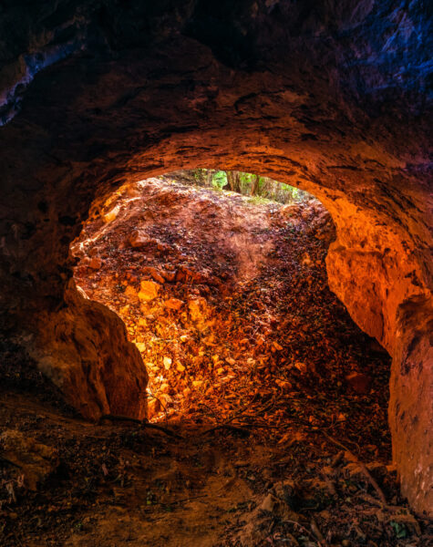 Low angle shot of a round hole as a cave entrance A low angle shot of a round hole as a cave entrance