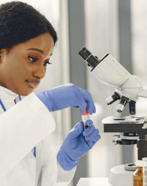 Female Scientist Working in The Laboratory Using a Microscope Medical doctor girl working with a microscope. Young female scientist doing vaccine research.